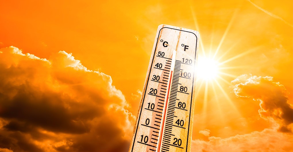 A thermometer under a scorching sun indicates a high temperature, suggesting a hot day.