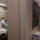 A doctor is examining a patient in a hospital room