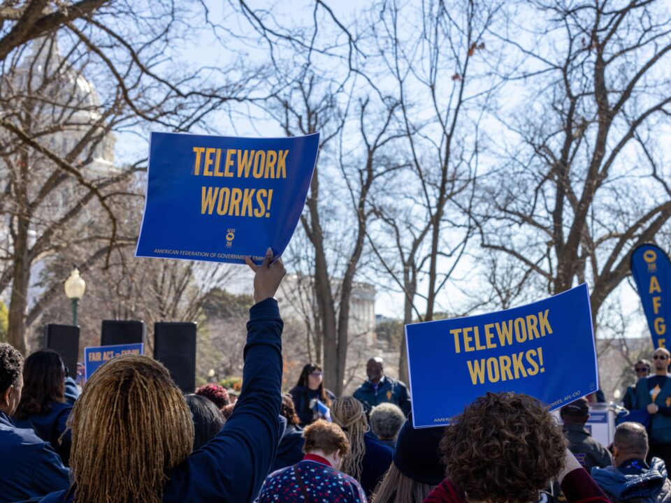 people holding banners of telework works